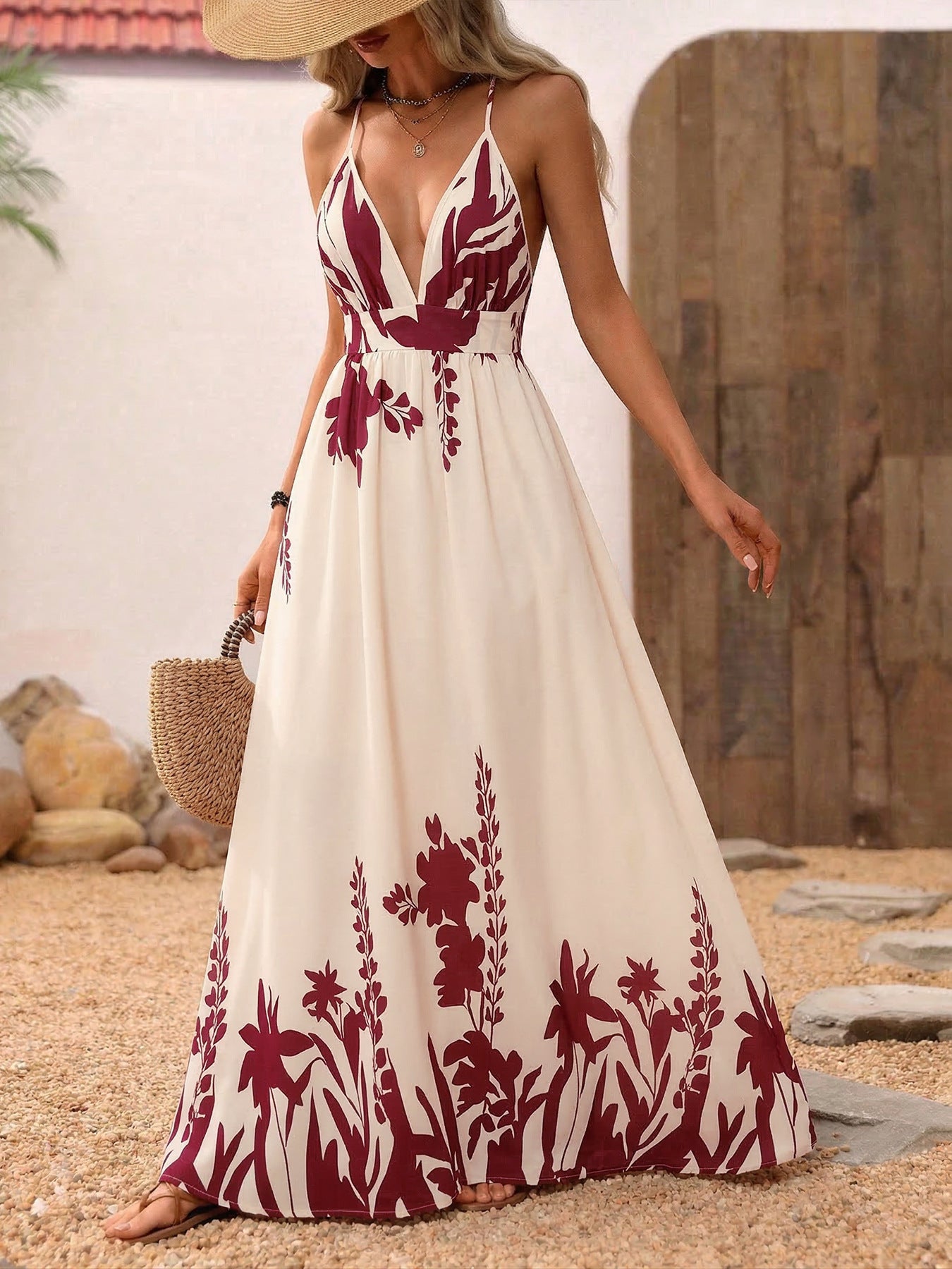 Woman wearing a white dress with red floral patterns outdoors.