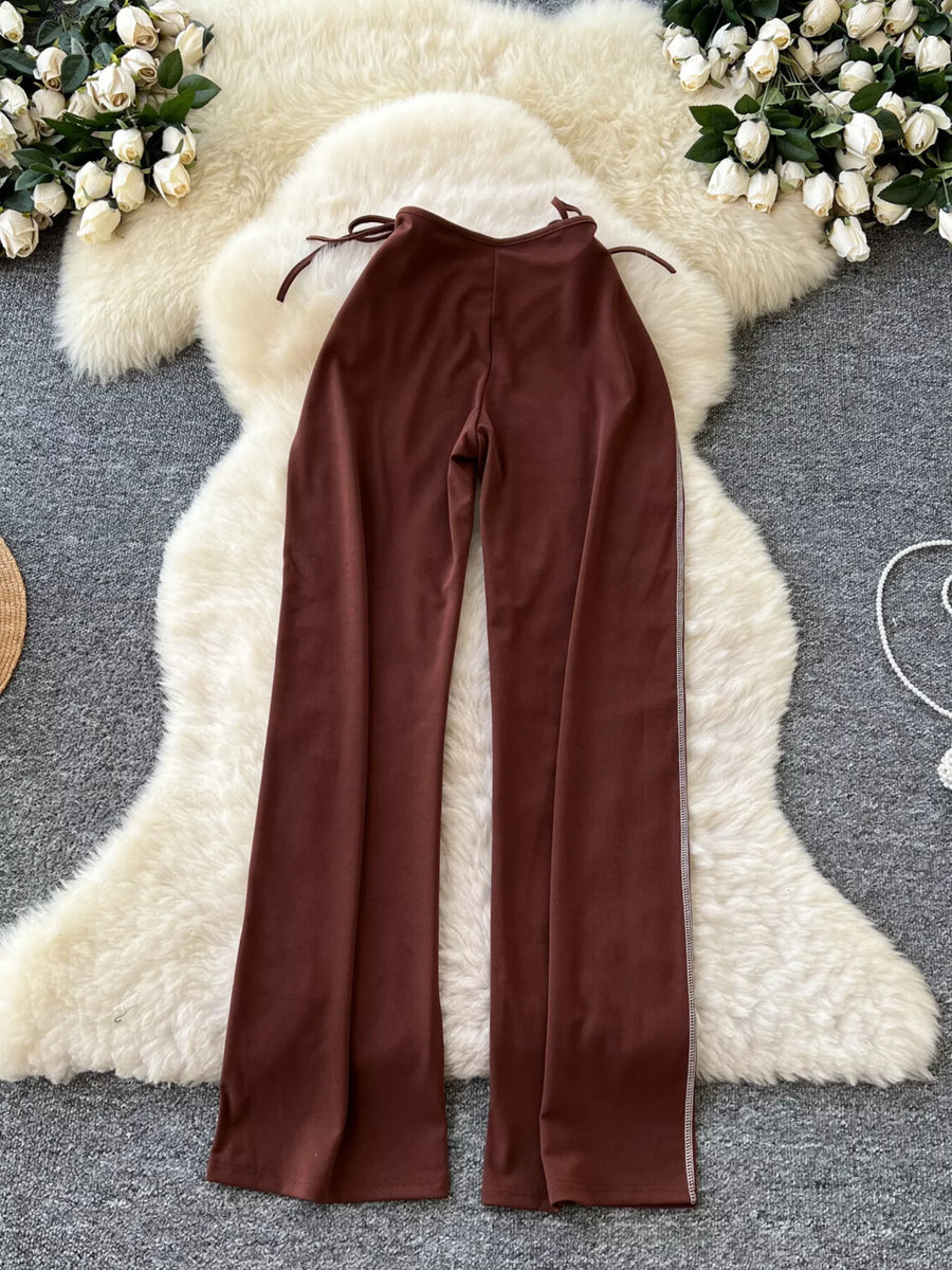 Brown pants displayed on a decorative white sheepskin rug with floral decorations.