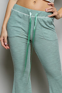 Green checkered pants with a drawstring on a gray background