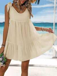 Woman in a beige dress on a beach with ocean view