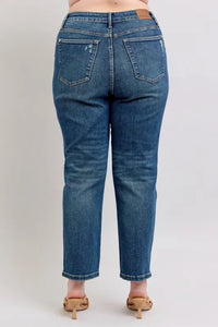 Person wearing blue jeans on a plain background