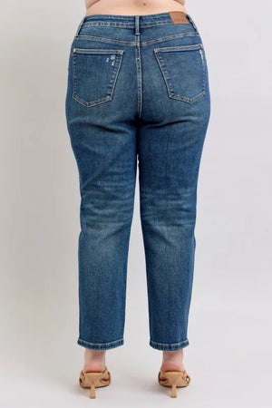 Person wearing blue jeans on a plain background