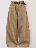 A pair of wide-leg, pleated khaki pants with a brown leather belt, displayed flat against a light gray background.