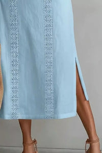 Light blue dress with intricate white embroidery on a neutral background