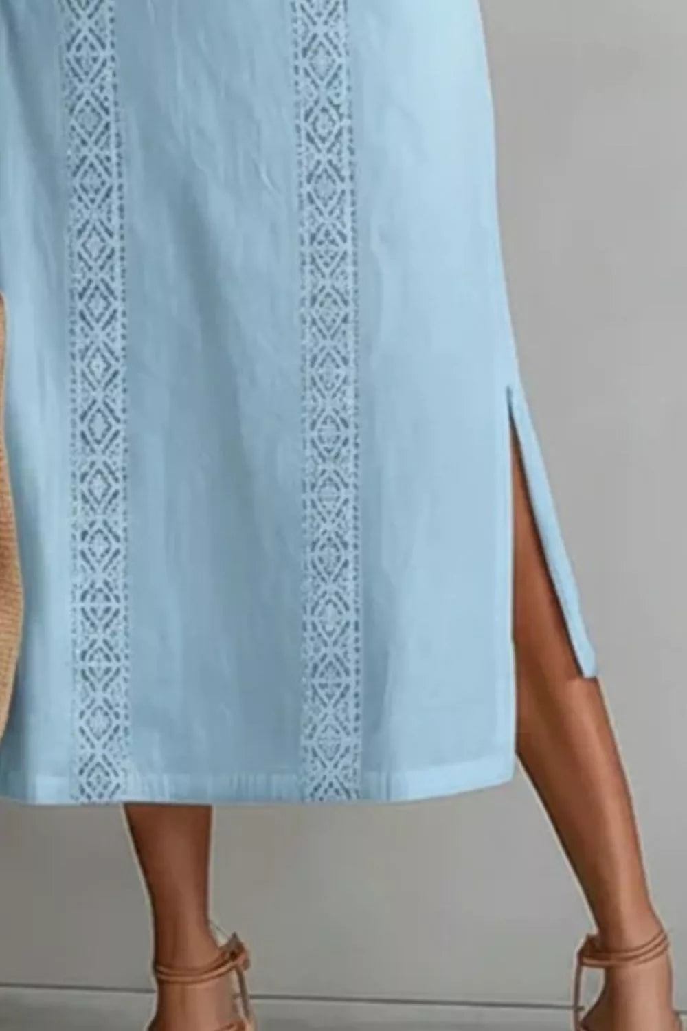 Light blue dress with intricate white embroidery on a neutral background