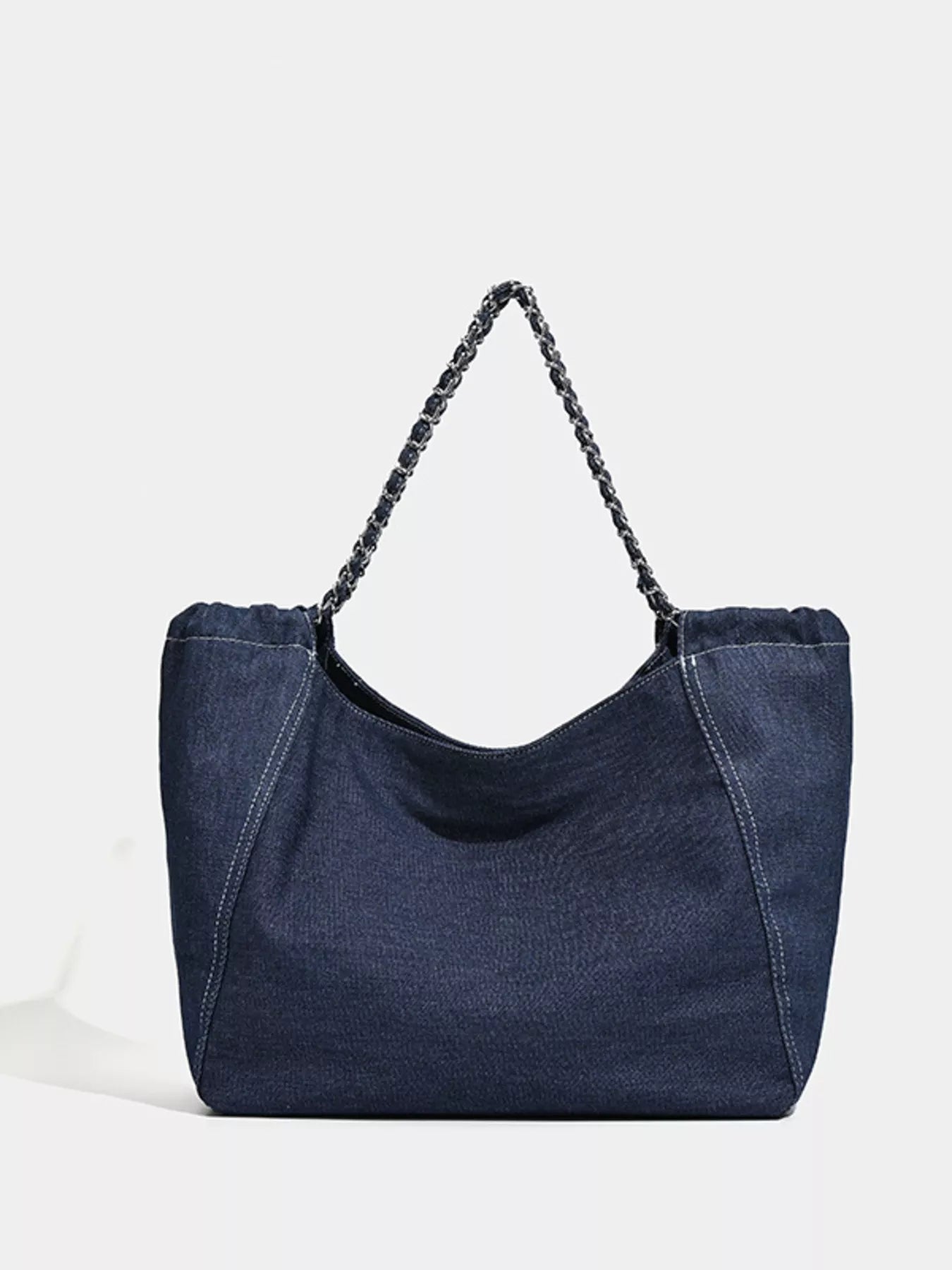Blue denim handbag with a braided handle on a white background