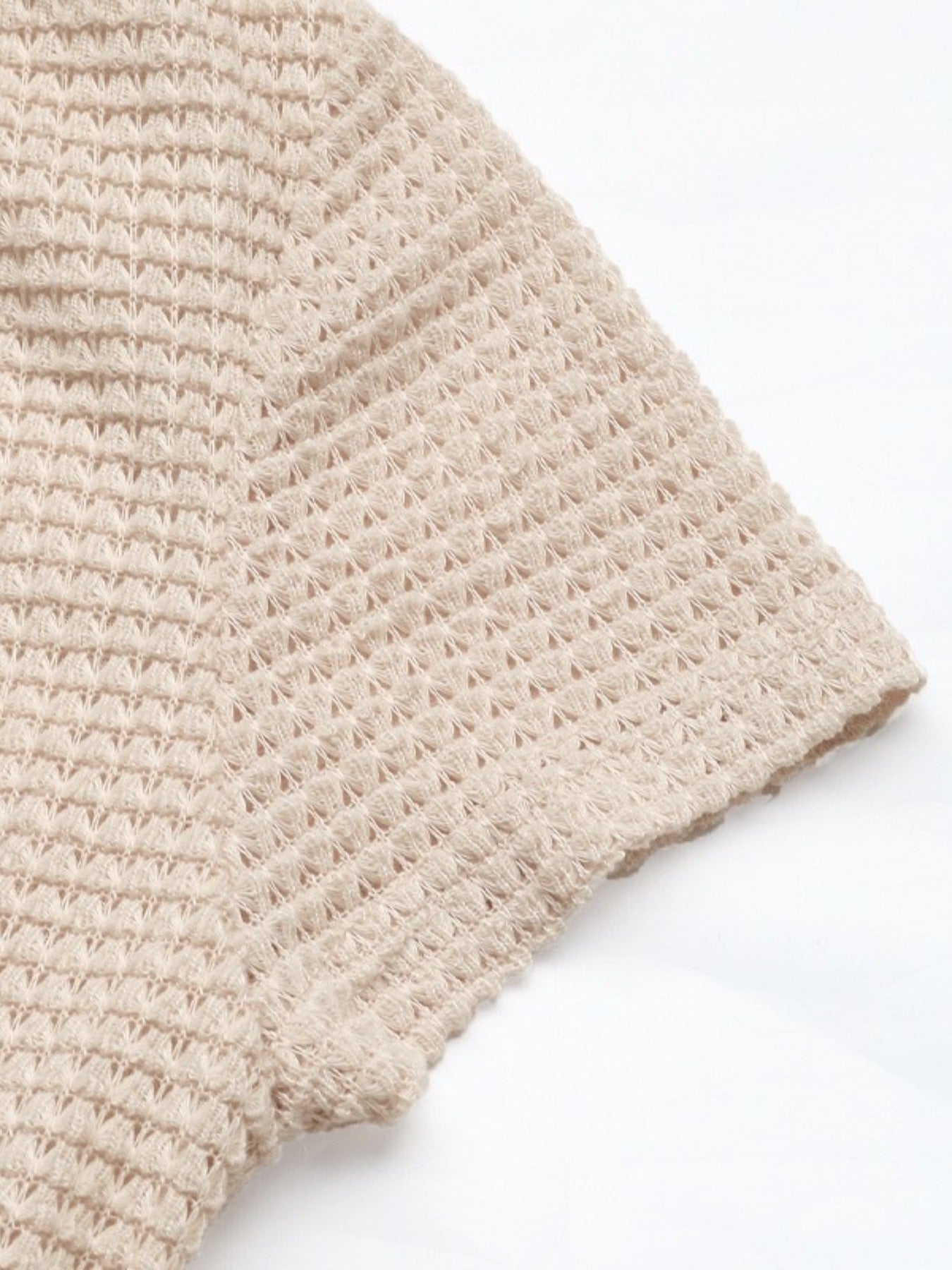 Close-up of a beige knitted fabric on a white background