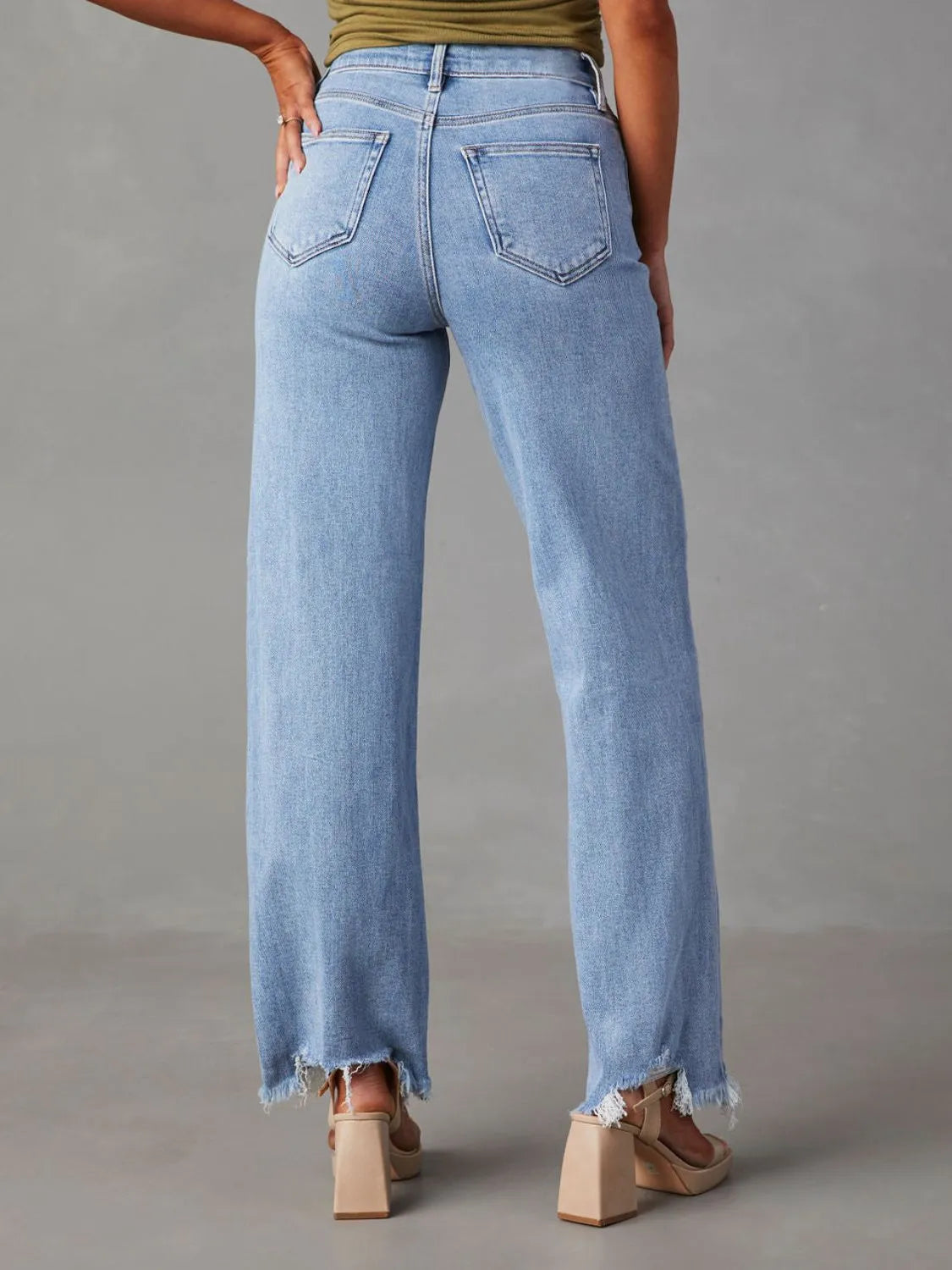 Light blue jeans worn by a person on a gray background
