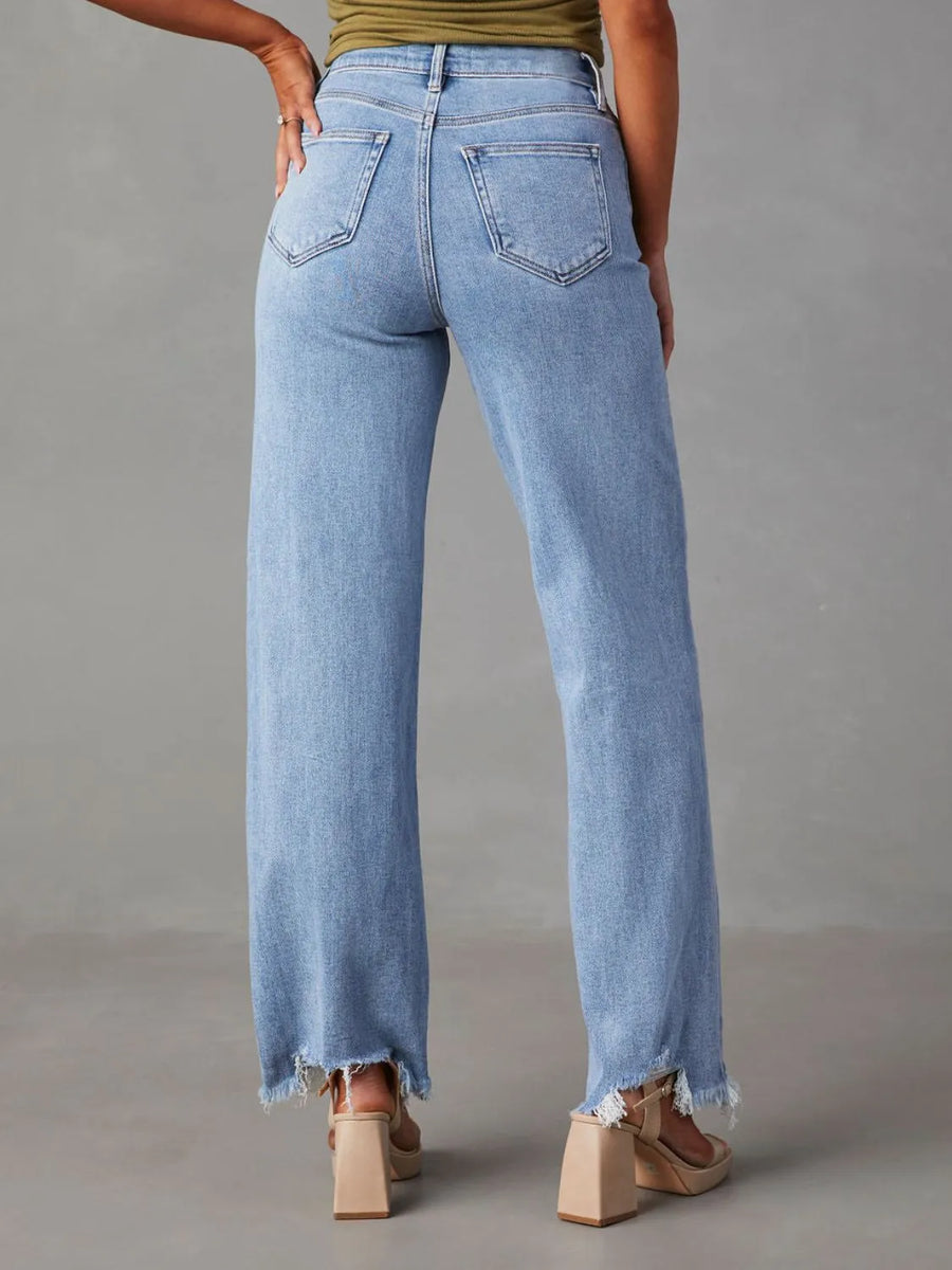 Light blue jeans worn by a person on a gray background