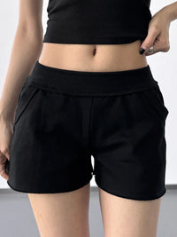 Person wearing black shorts on a plain background