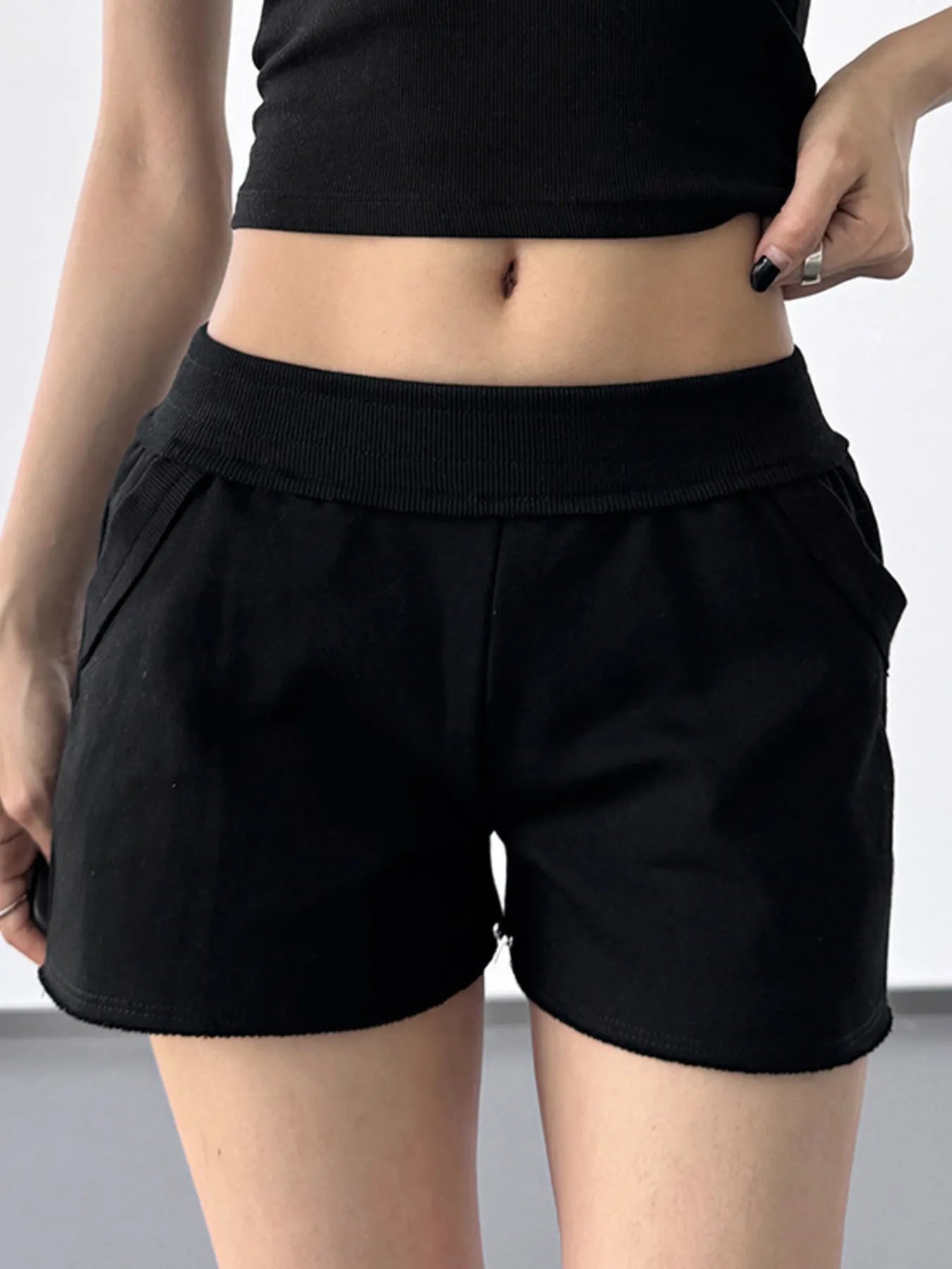 Person wearing black shorts on a plain background