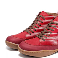 Red high-top sneakers with brown laces on a white background