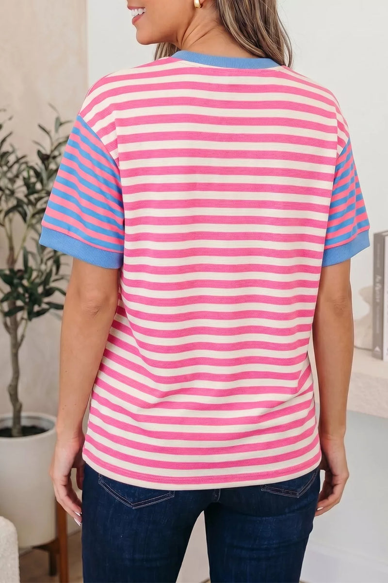 Person wearing a pink and blue striped shirt in an indoor setting