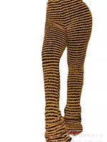 A pair of high-waisted, flared leggings with a textured, ribbed knit pattern in black and mustard yellow, shown on a white background.