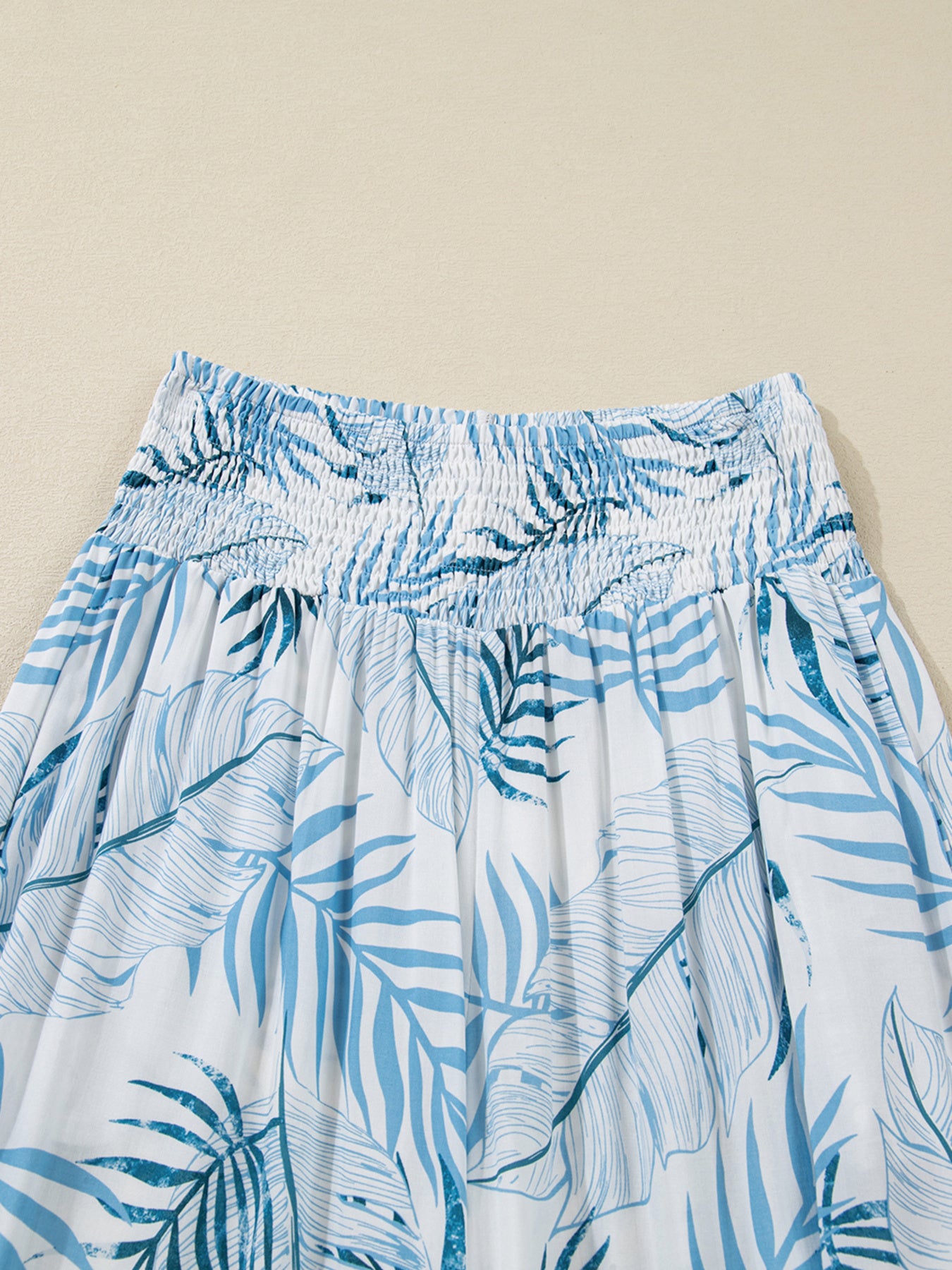 Blue and white leaf-patterned skirt on a beige background