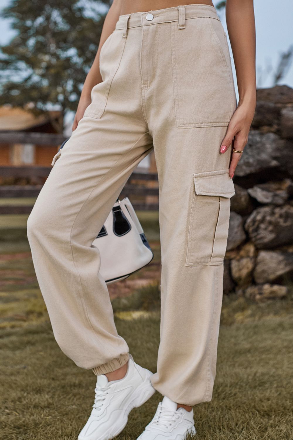 Person wearing beige cargo pants outdoors with a blurred background