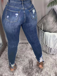 Blue jeans worn by a person on a soft surface with a neutral background