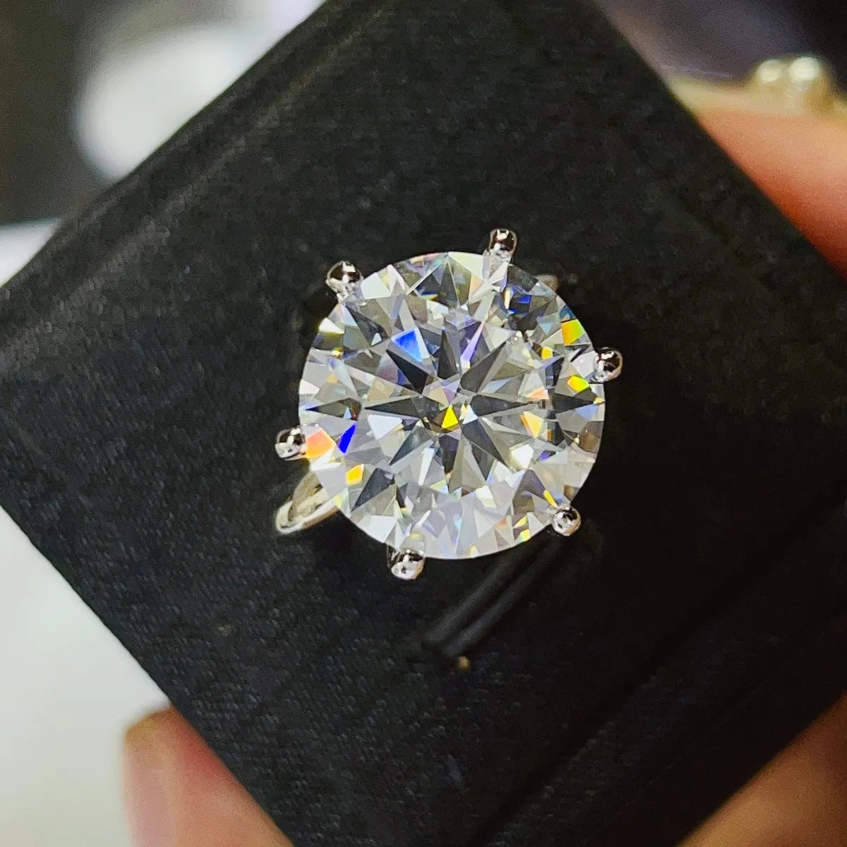 Diamond ring in a black box held by a hand