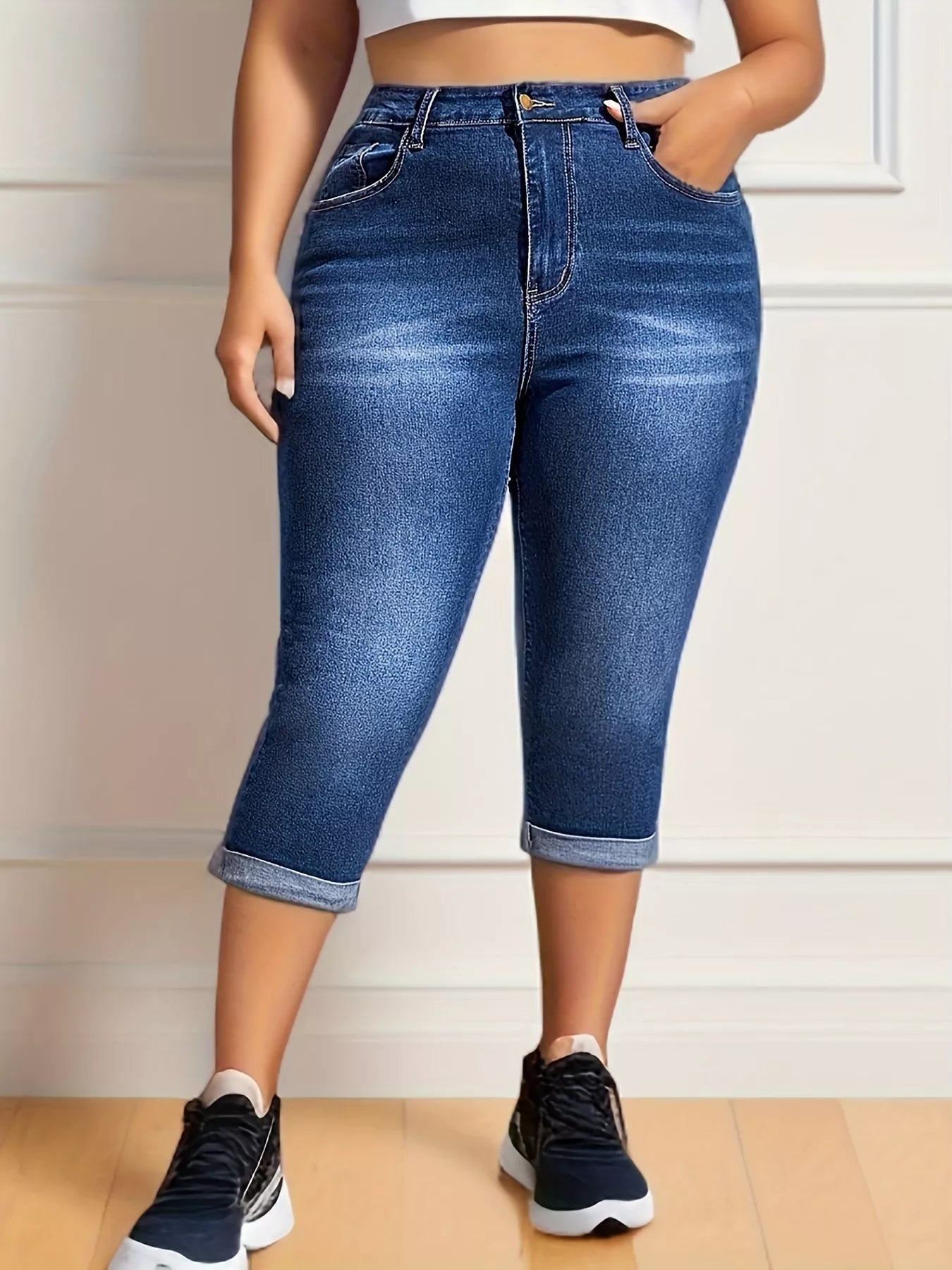 Person wearing blue jeans with a neutral background