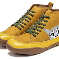 Yellow high-top sneakers with green laces and a cat face design on a white background