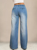 Blue jeans worn by a person on a beige background