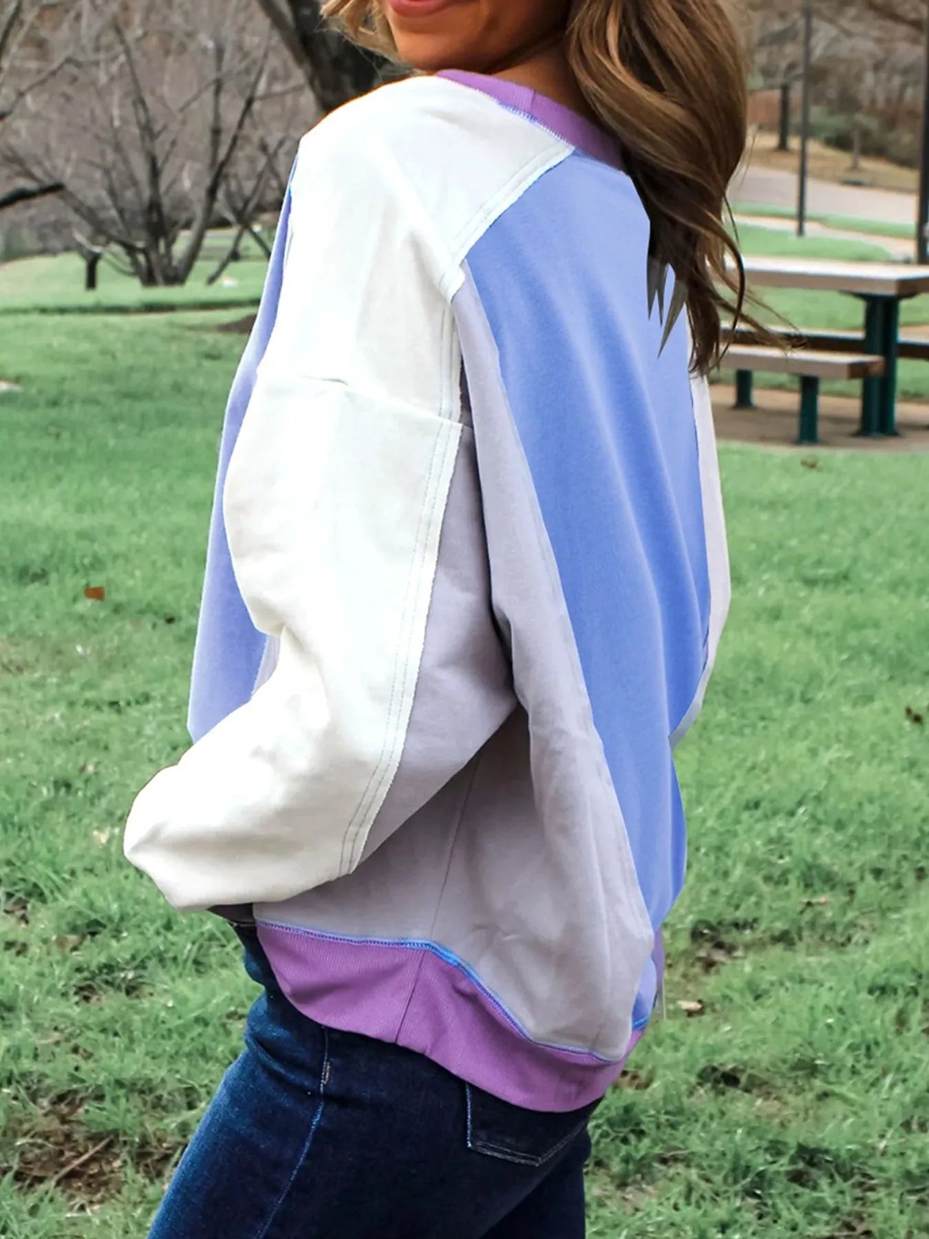 Person wearing a colorful sweater in a park setting