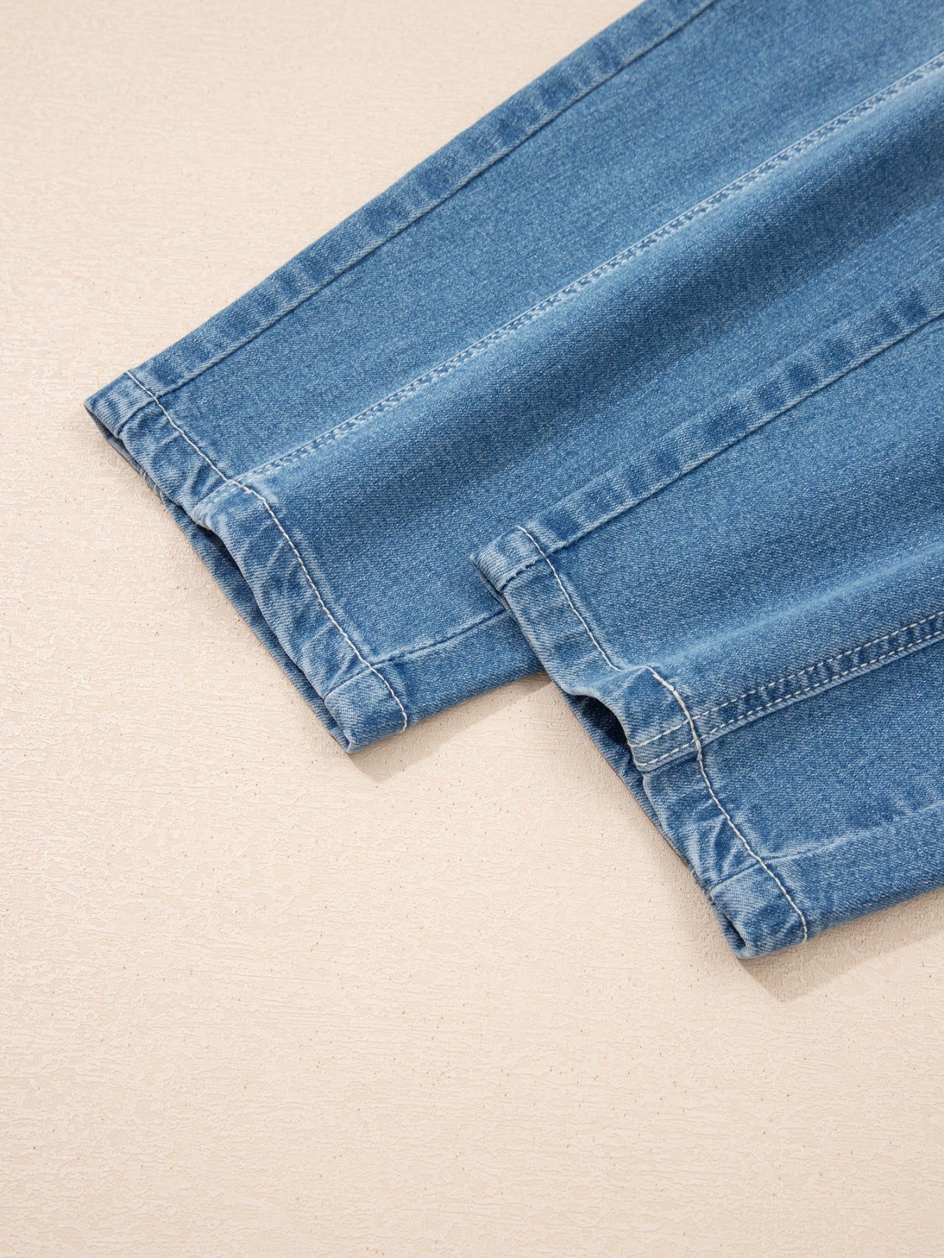 Close-up of blue denim shorts on a beige background