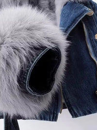 Close-up of a denim jacket with fur-lined hood and blue jeans.