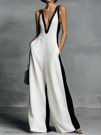 Woman wearing a black and white jumpsuit against a gray background