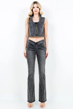 Woman wearing a denim vest and jeans on a white background
