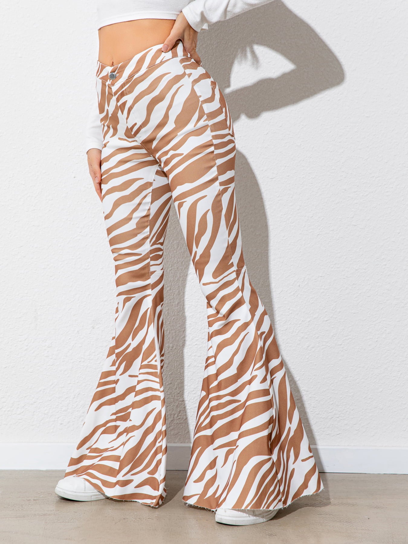 Zebra print flared pants worn by a person against a white background