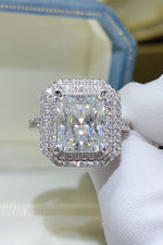 Diamond ring held by a hand wearing a white glove