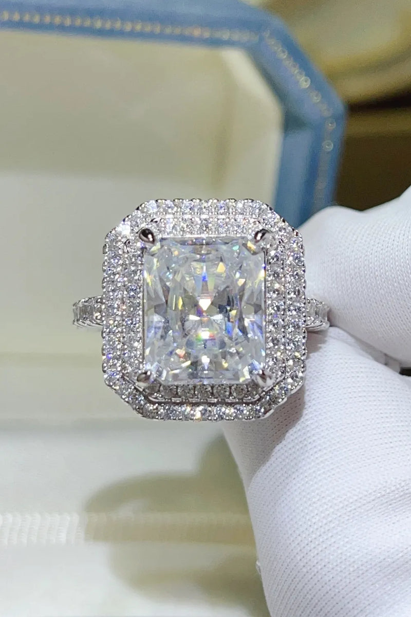 Diamond ring held by a hand wearing a white glove