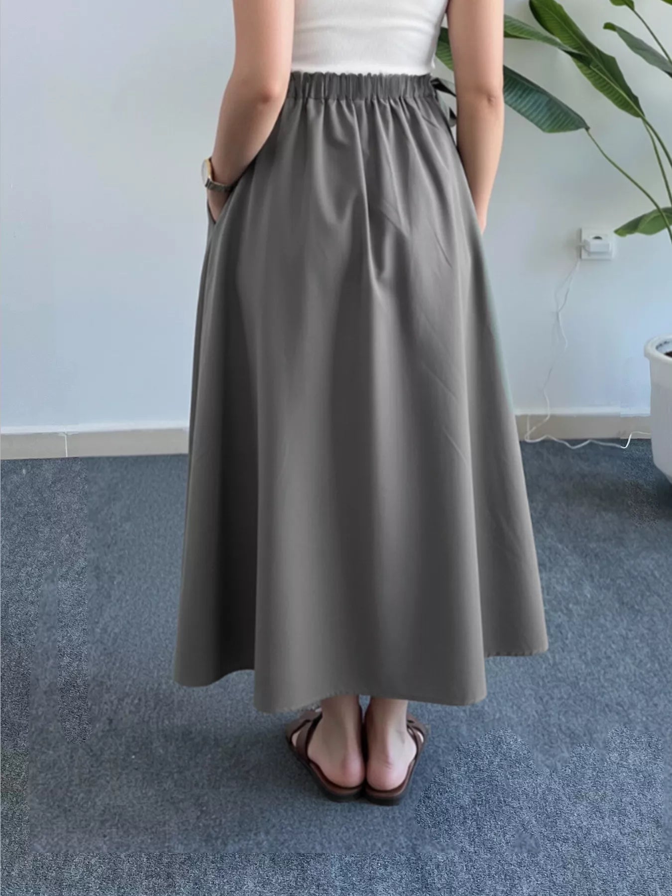 Person wearing a gray skirt in an indoor setting