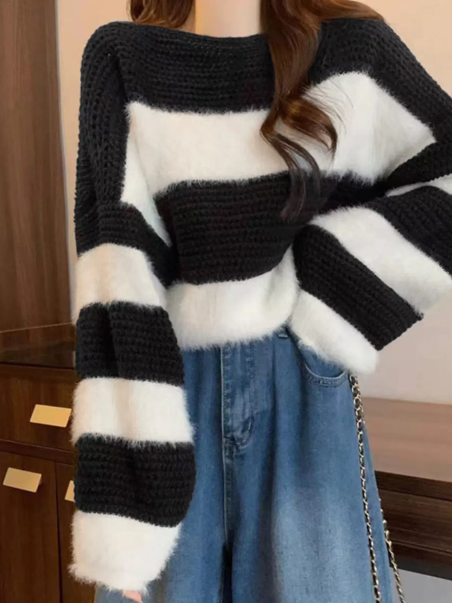Person wearing a black and white striped sweater with a blurred background