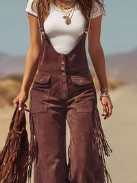 Person wearing brown suede overalls with fringe details in a desert setting