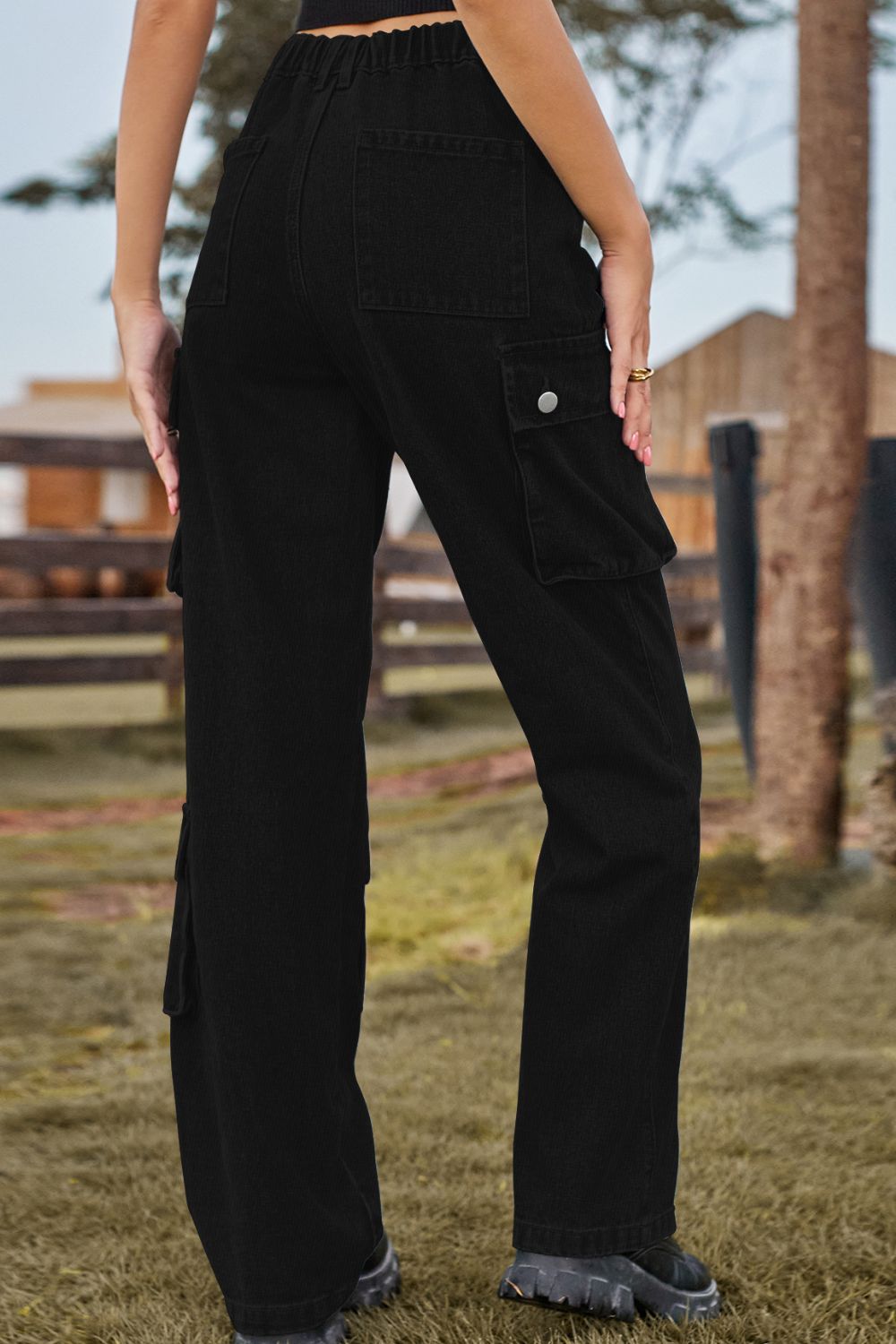 Person wearing black cargo pants standing outdoors with a blurred background