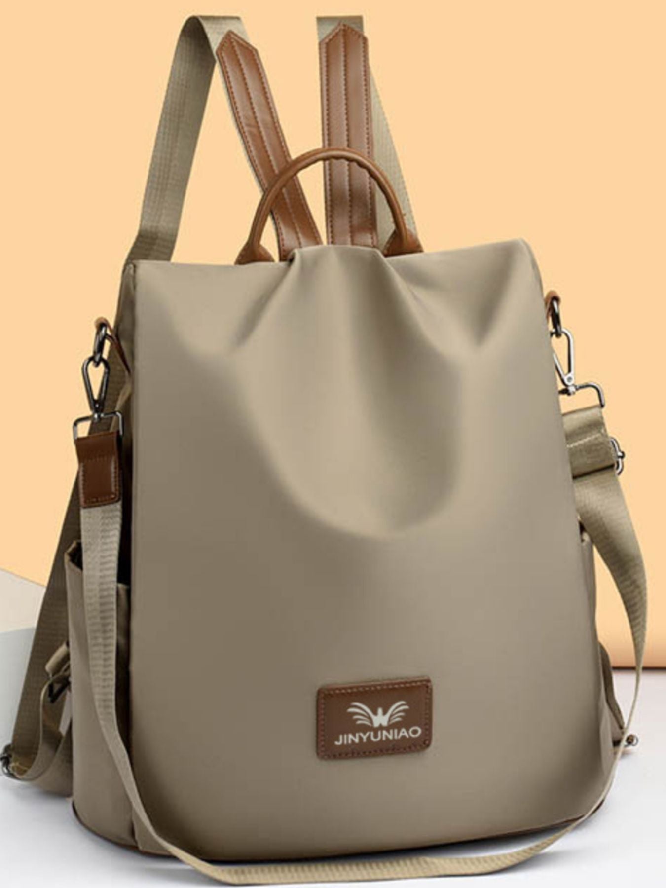 Beige backpack with brown straps and a visible brand logo on a light beige background