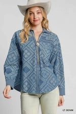 Woman wearing a blue patterned shirt with a silver tassel and a white cowboy hat on a gray background