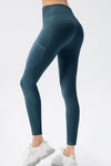 Teal leggings worn by a person on a white background