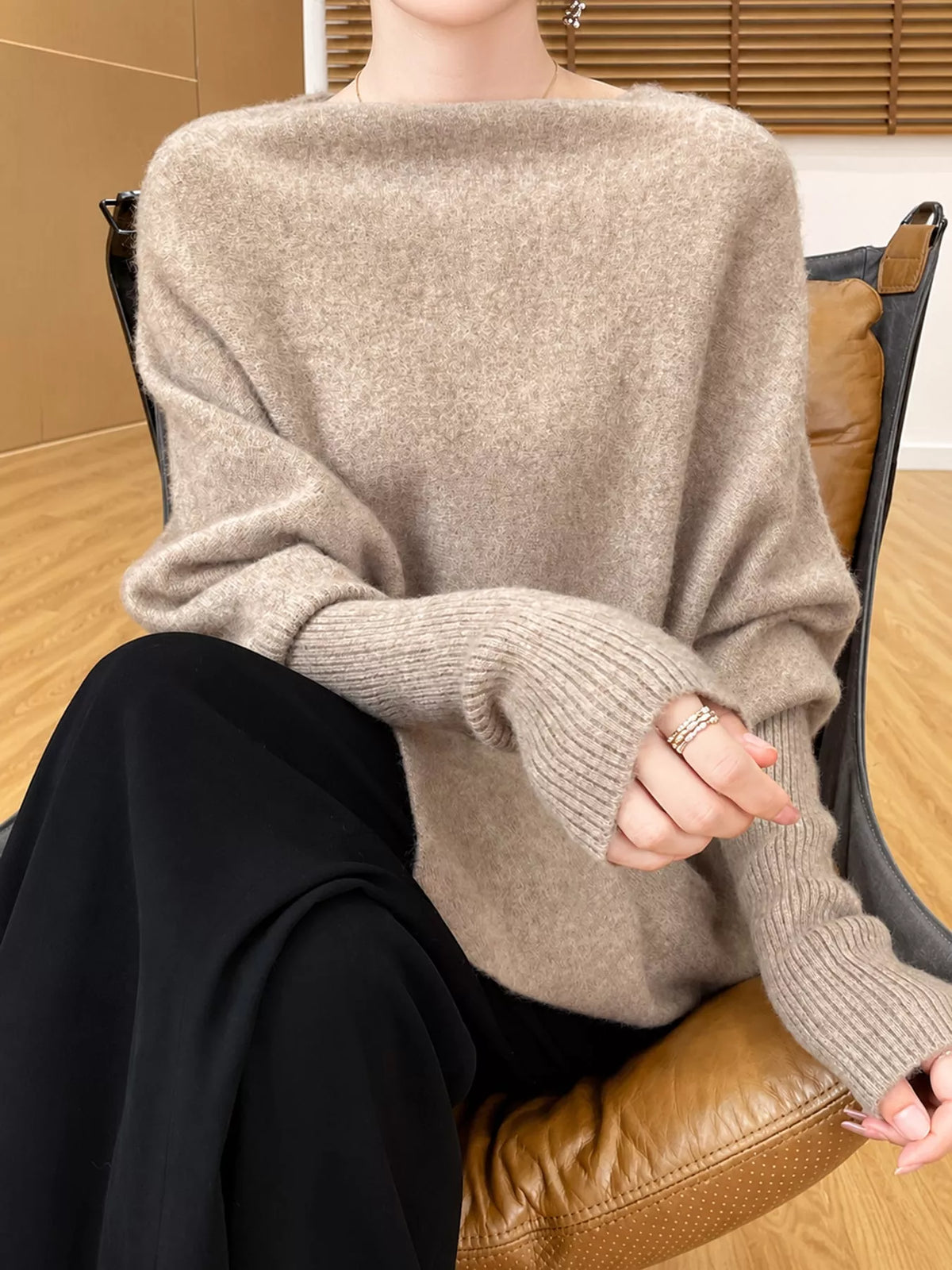 A view of a mannequin sitting in a chair wearing Asymmetrical Lantern Sleeve Sweater