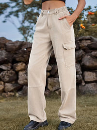 Person wearing beige cargo pants standing in front of a stone wall.
