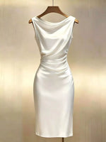 White dress on a wooden hanger against a beige background