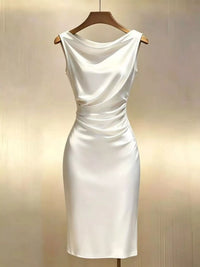 White dress on a wooden hanger against a beige background