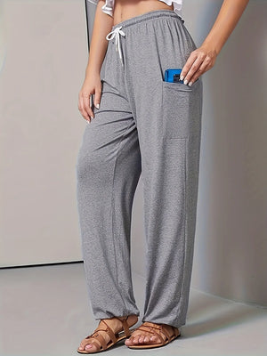 Gray lounge pants worn by a person on a plain background