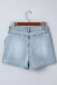 Light blue denim shorts on a hanger against a white background