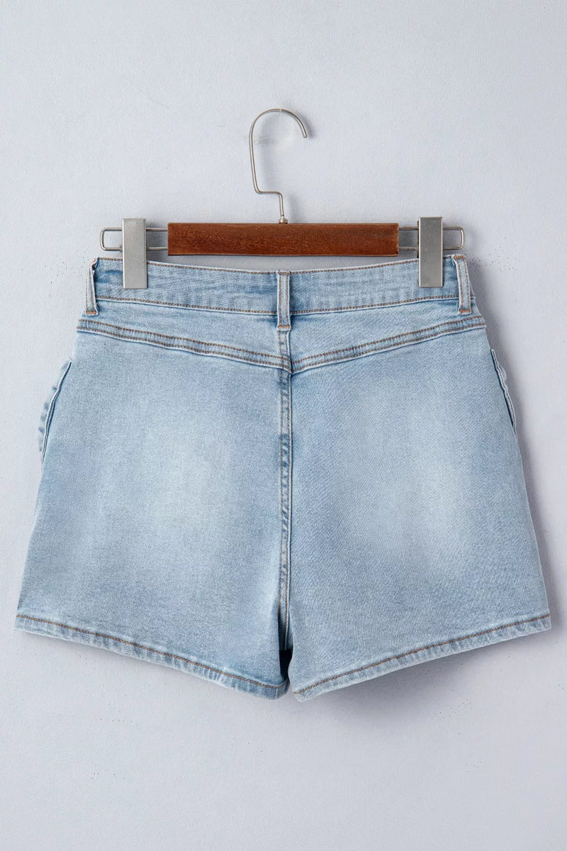 Light blue denim shorts on a hanger against a white background