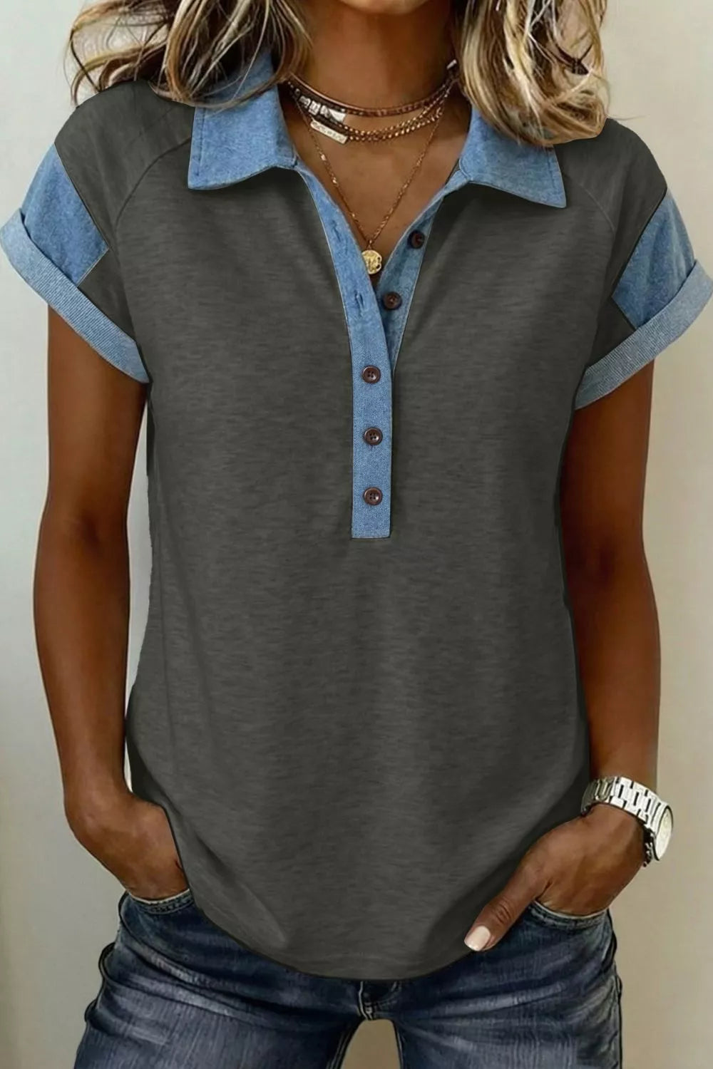 Gray polo shirt with blue accents worn by a person against a neutral background