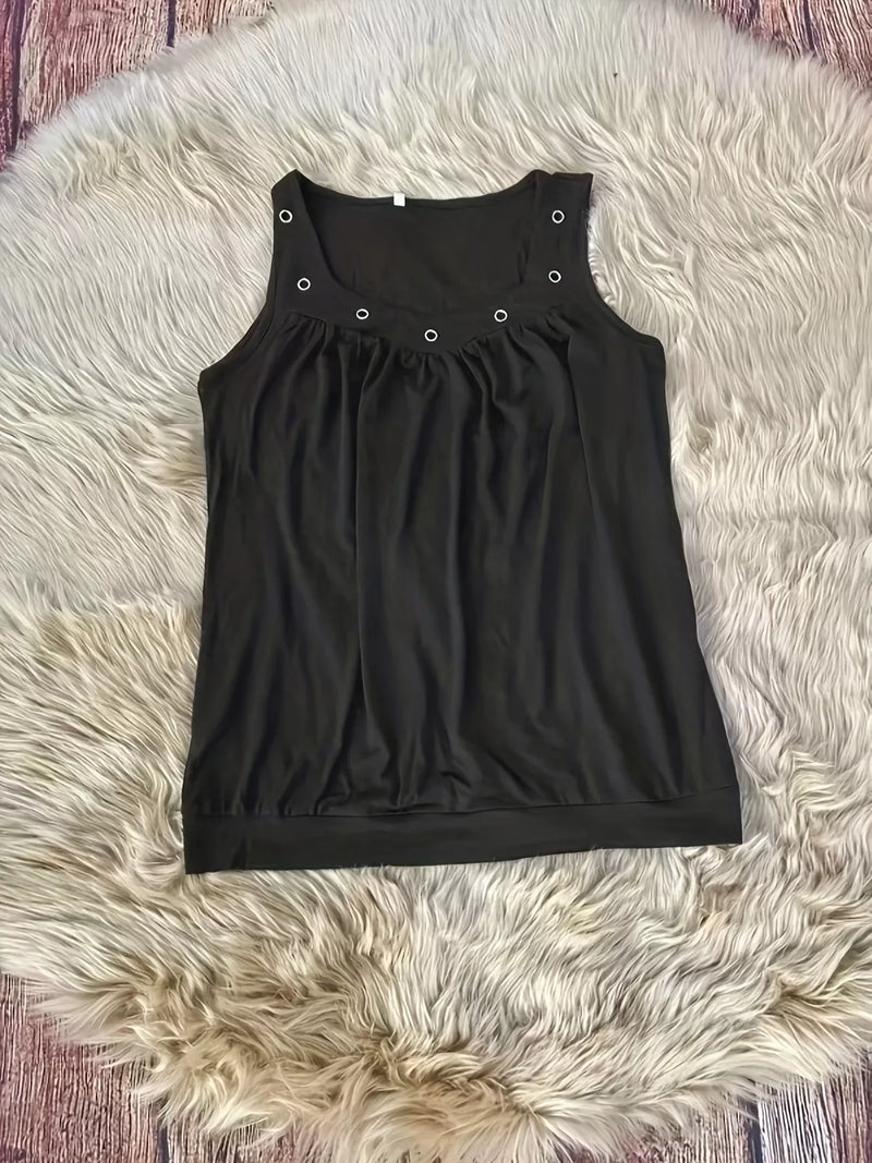 Black tank top with button details on a fluffy white rug
