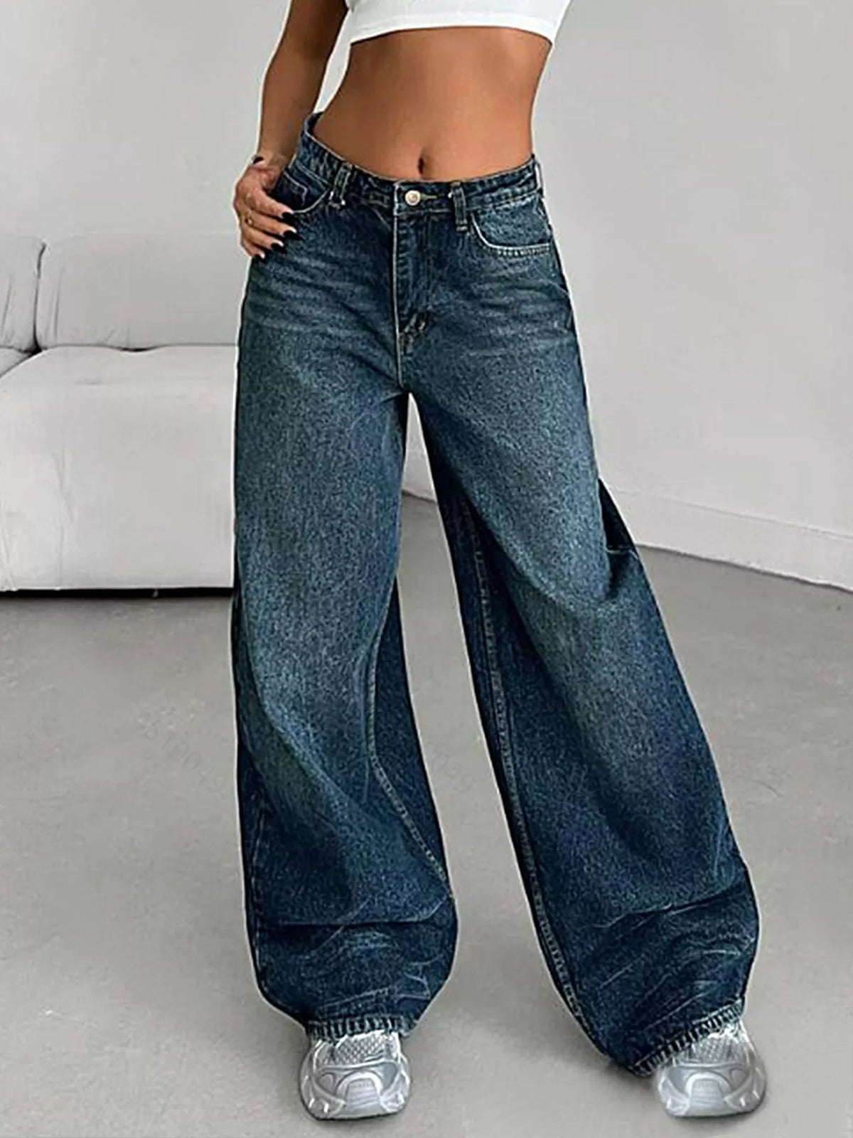Person wearing wide-leg jeans in a minimal indoor setting